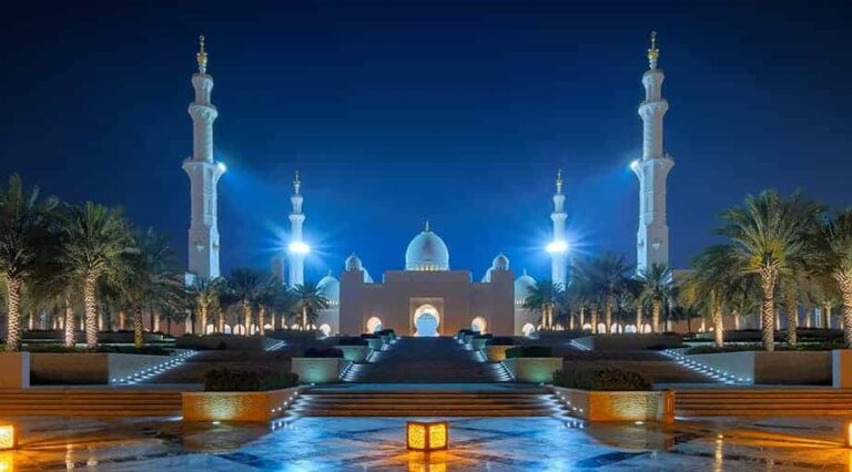 A mosque lit up at dusk
